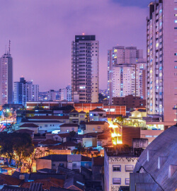 Cidade, prédios iluminados no anoitecer.